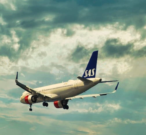 Avion de ligne SAS en vol dans un ciel dégagé.