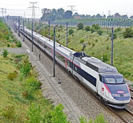 Train à grande vitesse sur une voie ferrée électrifiée.