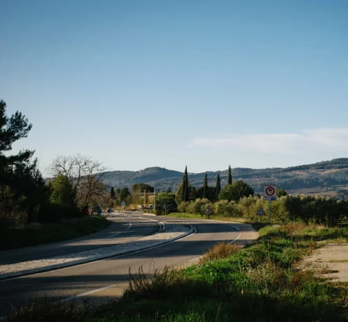 Route bordée de végétation qui traverse un paysage vallonné du Var.